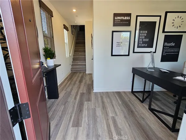 a view of a hallway with wooden floor and stairs