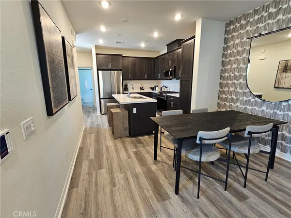 a kitchen with a table chairs refrigerator and microwave