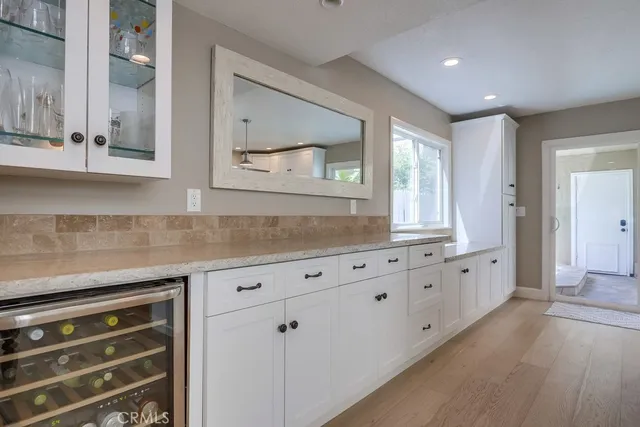 a room with granite countertop white cabinets and window