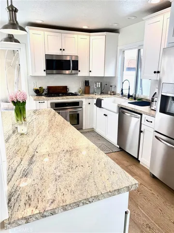 a kitchen with stainless steel appliances kitchen island granite countertop a stove a sink and a microwave