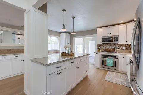 a kitchen with granite countertop a stove a sink and a microwave