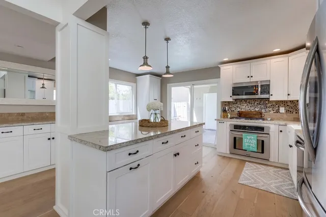 a kitchen with granite countertop a stove a sink and a microwave