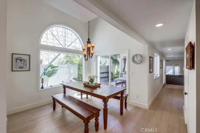 a dining room with furniture a chandelier and wooden floor