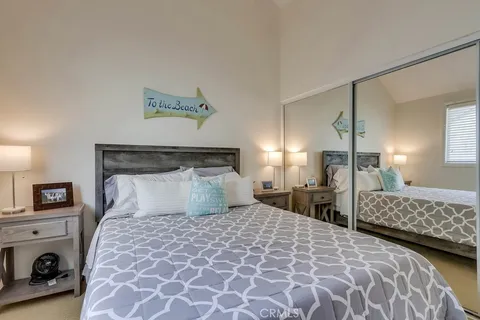 a bedroom with a large bed and a lamp on dresser