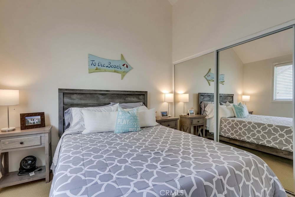 225 20th Street Huntington Beach, CA 92648 - Photo 32 of 47 a bedroom with a large bed and a lamp on dresser