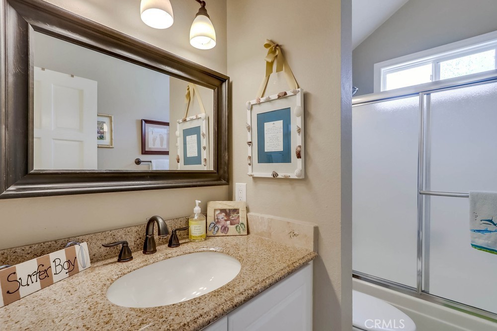 225 20th Street Huntington Beach, CA 92648 - Photo 33 of 47 a bathroom with a granite countertop sink and a mirror