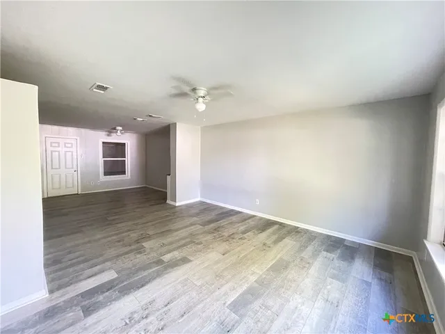 a kitchen with stainless steel appliances kitchen island granite countertop a refrigerator a stove top oven a sink with island and chairs