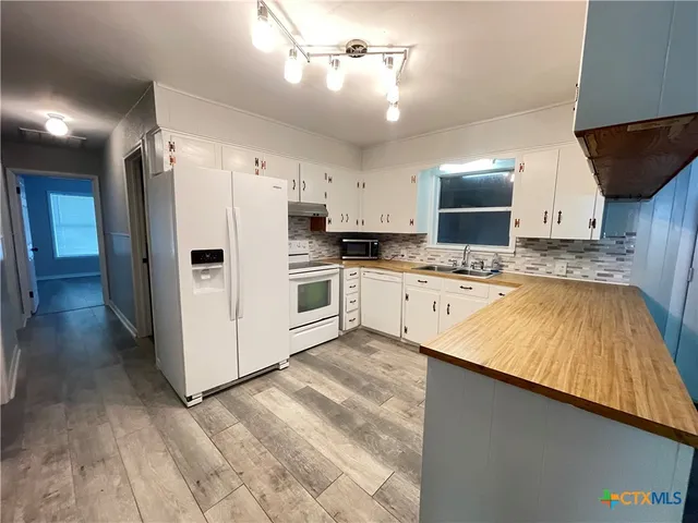 a kitchen with kitchen island a white counter top space cabinets and stainless steel appliances