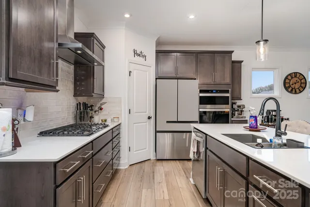 a kitchen with kitchen island stainless steel appliances a sink stove and refrigerator