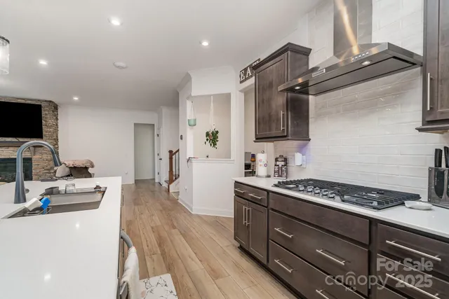 a kitchen with stainless steel appliances a stove top oven a sink a refrigerator and a granite counter tops