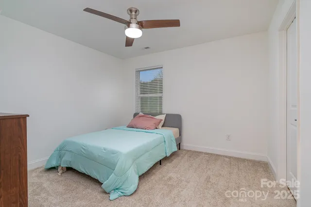 a bedroom with a bed and a ceiling fan