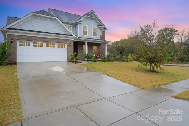 a front view of a house with a yard and potted plants