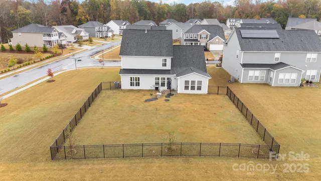 an aerial view of residential houses with outdoor space and lake view