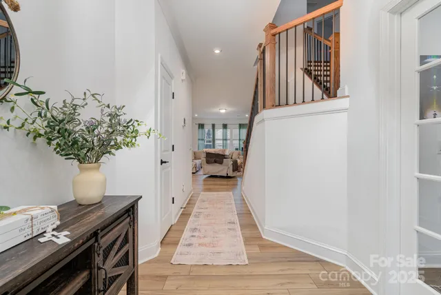 a view of entryway and hall with wooden floor