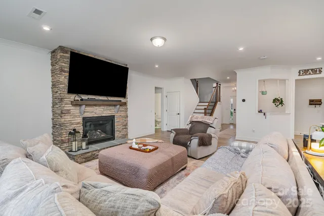 a living room with furniture a fireplace and a flat screen tv