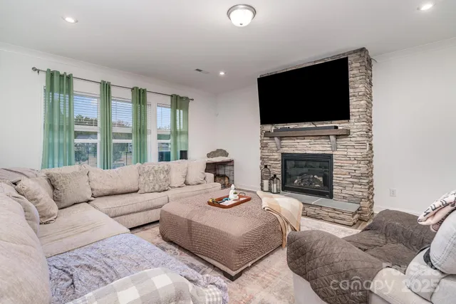 a living room with furniture a flat screen tv and a fireplace