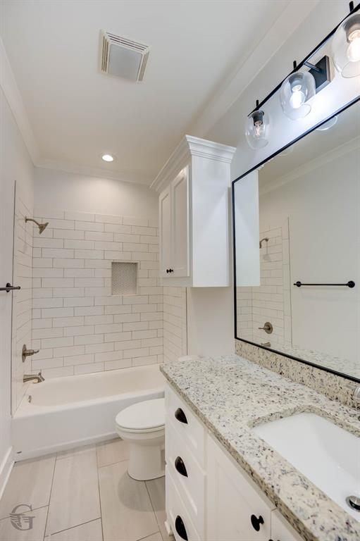 605 Meridian Way Benton, LA 71006 - Photo 19 of 29 Bathroom featuring a white subway tile shower surround with a recessed niche, a built-in tub, and a white vanity with a light-colored speckled countertop