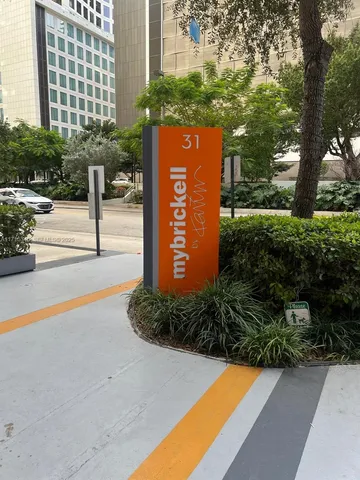 a view of a street with a bench and trees