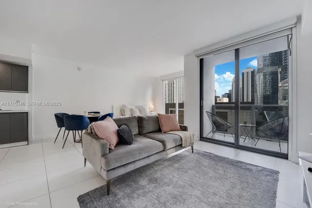 a living room with furniture and a glass door