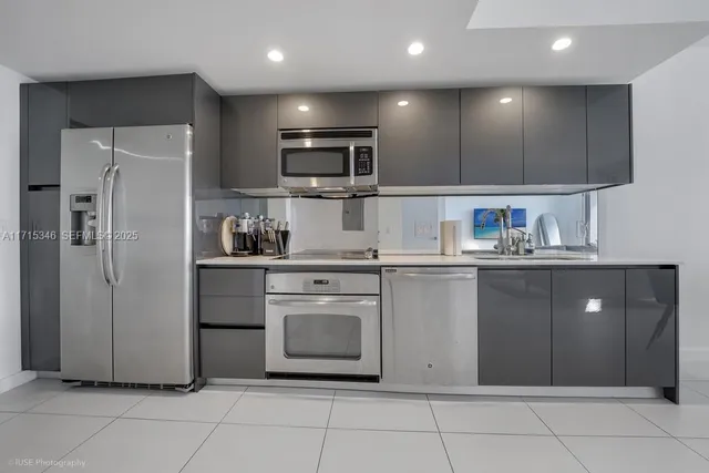 a kitchen with stainless steel appliances granite countertop a refrigerator and a sink
