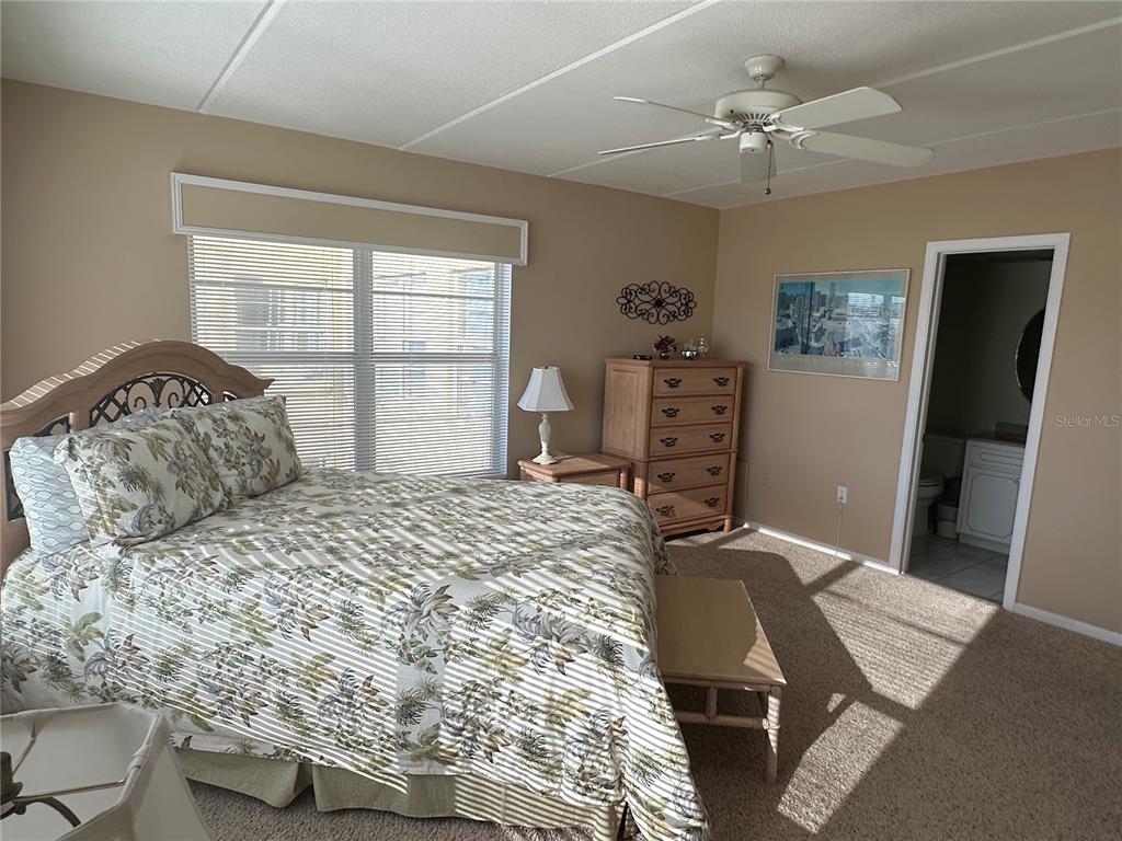 3808 Gulf Of Mexico Drive, Unit E211 Longboat Key, FL 34228 - Photo 13 of 34 a bedroom with a bed and dresser with mirror