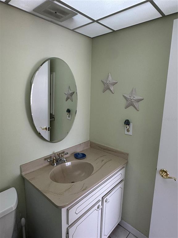3808 Gulf Of Mexico Drive, Unit E211 Longboat Key, FL 34228 - Photo 14 of 34 a bathroom with a sink and a mirror