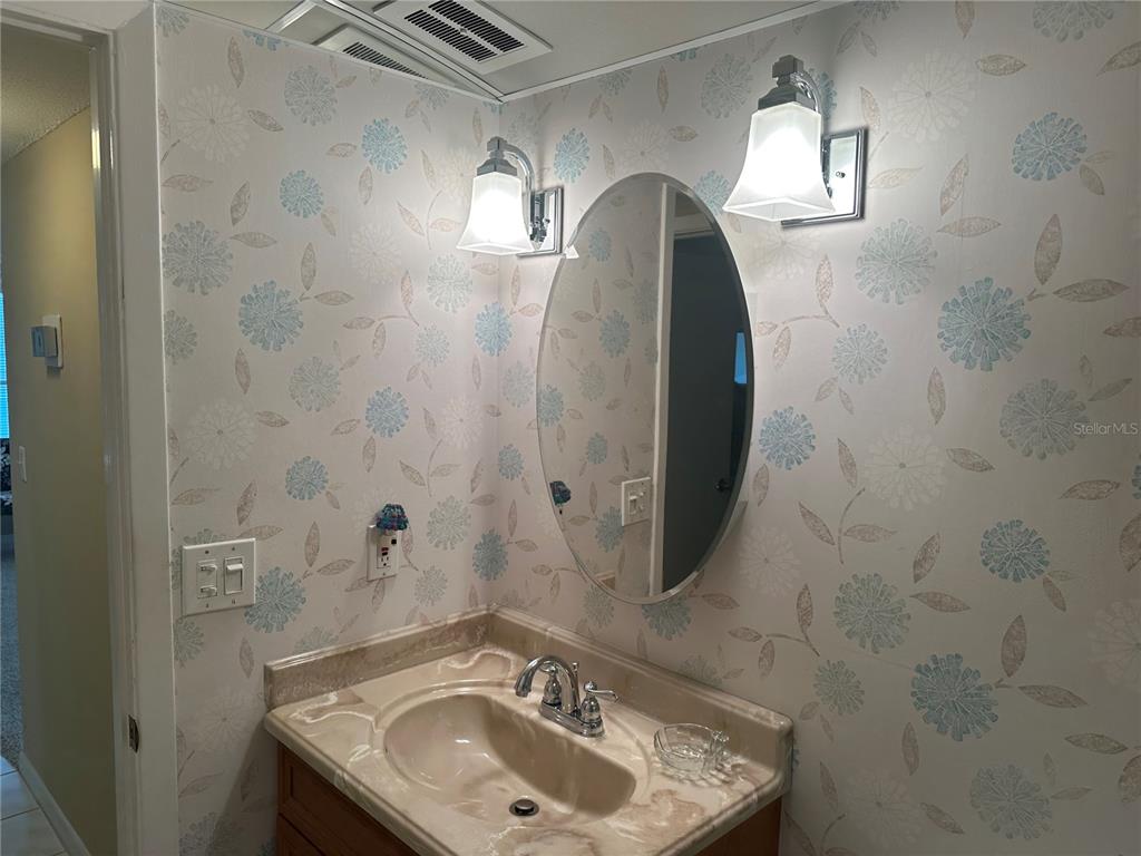 3808 Gulf Of Mexico Drive, Unit E211 Longboat Key, FL 34228 - Photo 20 of 34 a bathroom with a sink and mirror