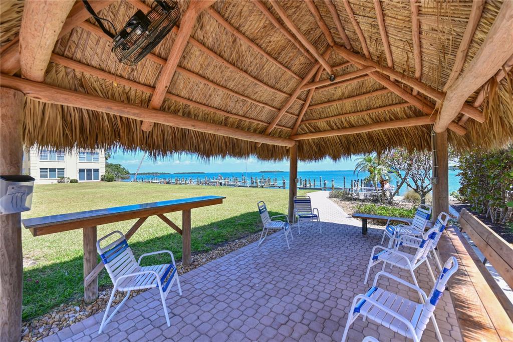 3808 Gulf Of Mexico Drive, Unit E211 Longboat Key, FL 34228 - Photo 29 of 34 a view of a table and chairs under an umbrella