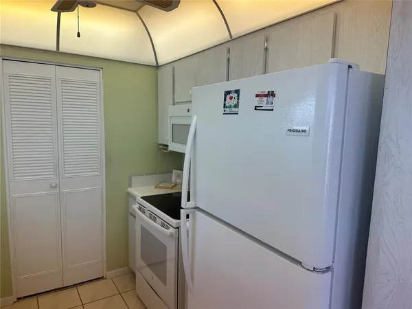 a white refrigerator freezer and a stove sitting inside of a kitchen