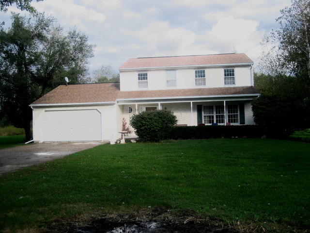a front view of a house with a garden and yard