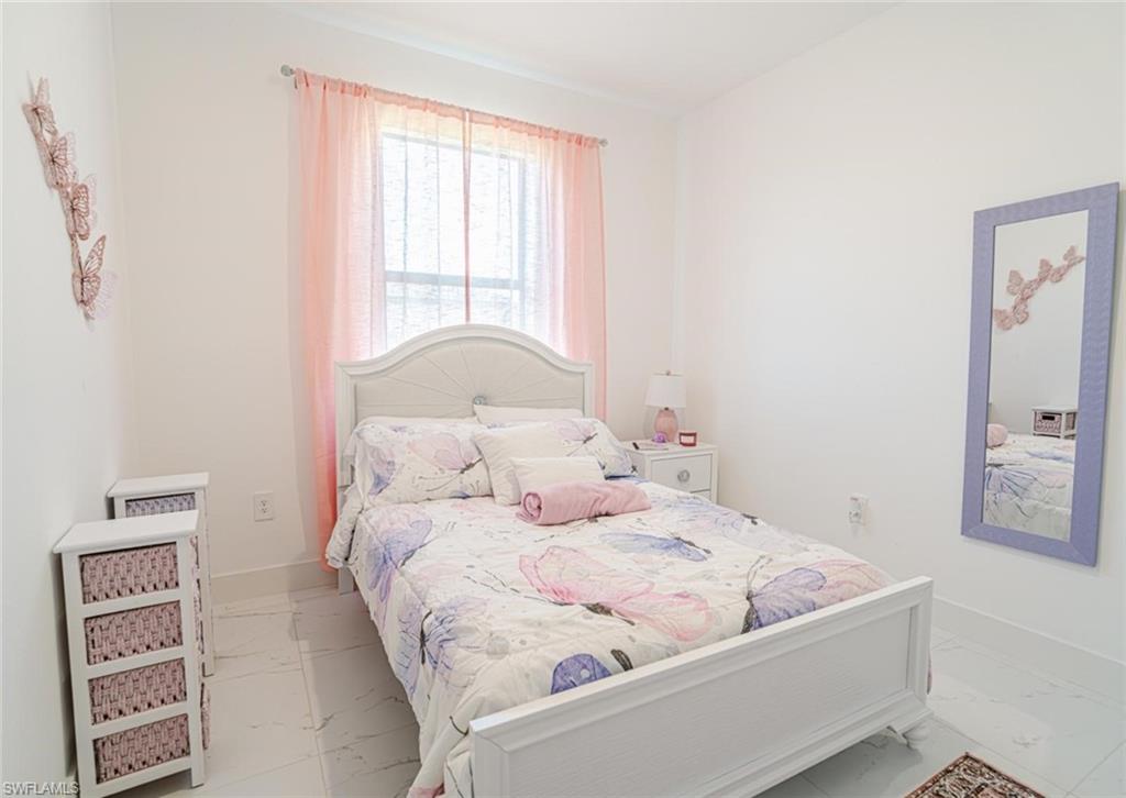 907 Homestead Road South Lehigh Acres, FL 33974 - Photo 19 of 43 Bright interior space with white walls and light-colored tile flooring