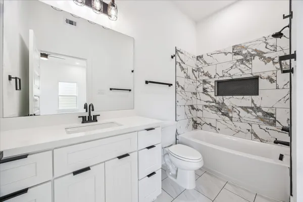 a bathroom with a sink toilet vanity and bathtub