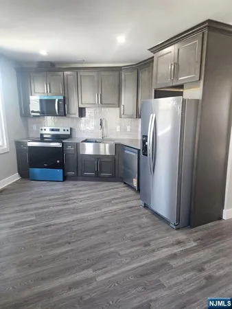 a kitchen with stainless steel appliances granite countertop a refrigerator a sink and a stove