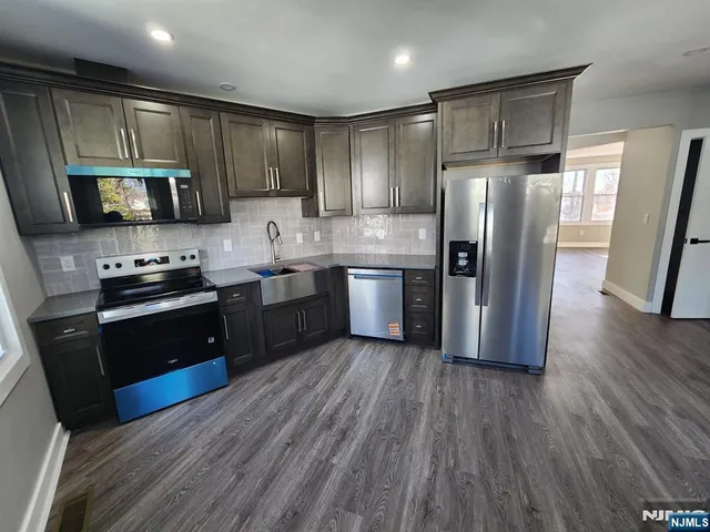 a kitchen with stainless steel appliances wooden floors and wooden cabinets