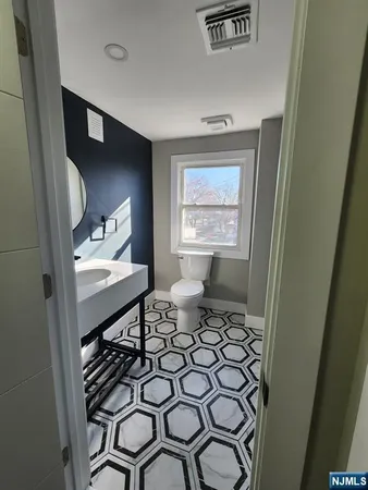 a bathroom with a sink toilet and mirror