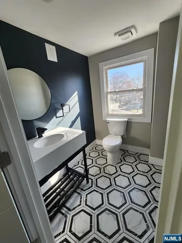 a living room with chairs and a painting on the wall