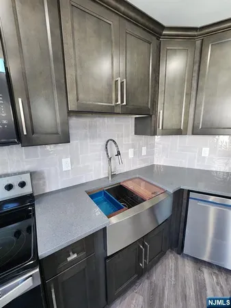a kitchen with a sink a refrigerator and cabinets