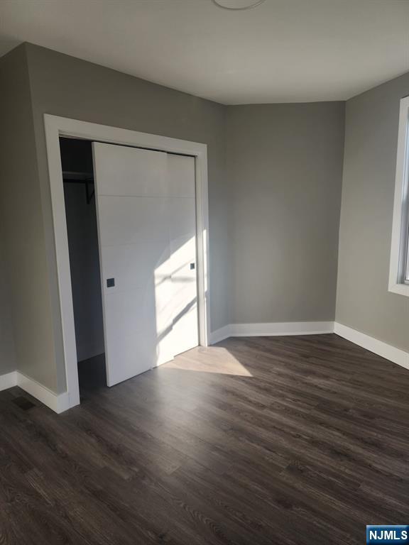 93 Hughes Street, Unit 3 Maplewood, NJ 07040 - Photo 6 of 23 a view of an empty room with wooden floor and a window