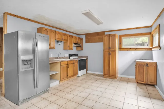 a kitchen with stainless steel appliances granite countertop a refrigerator and a stove top oven