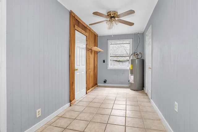 a view of a hallway with a chandelier fan and windows