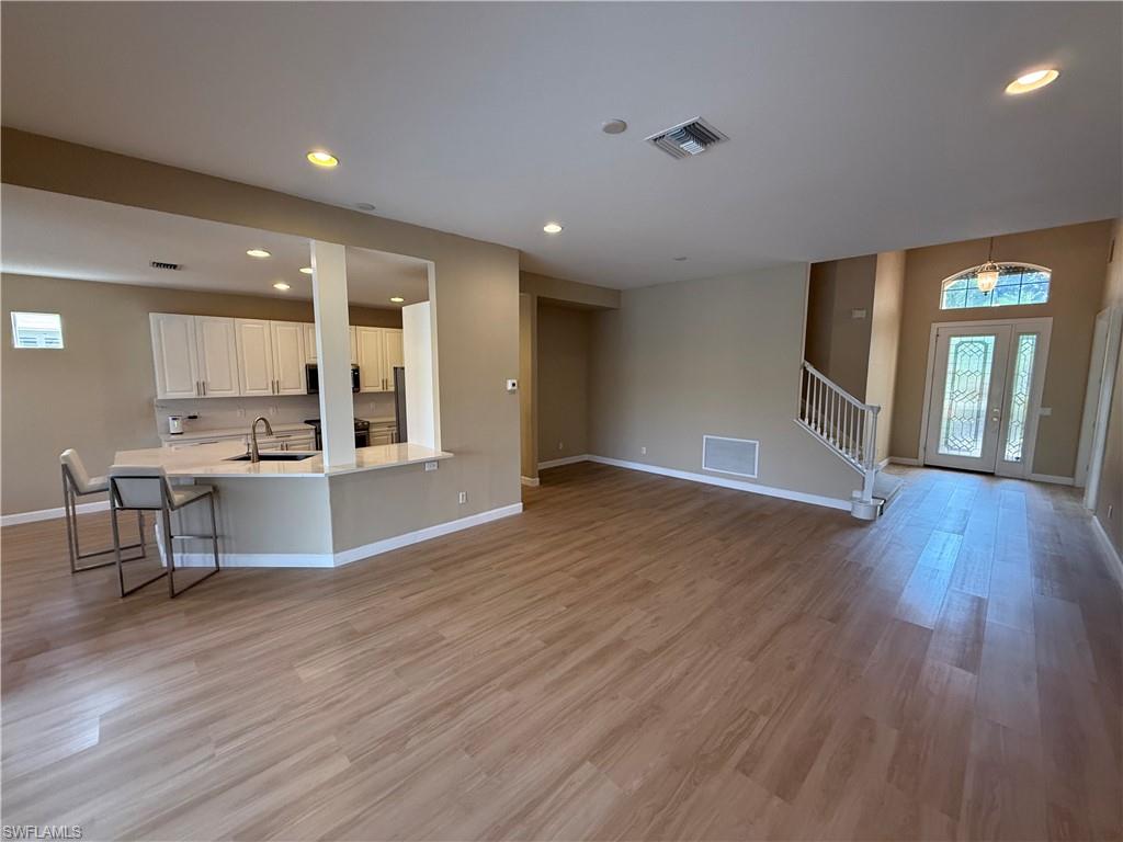 10228 Cobble Hill Road Bonita Springs, FL 34135 - Photo 12 of 31 Unfurnished living room with healthy amount of natural light, recessed lighting, stairs, and light wood-style floors