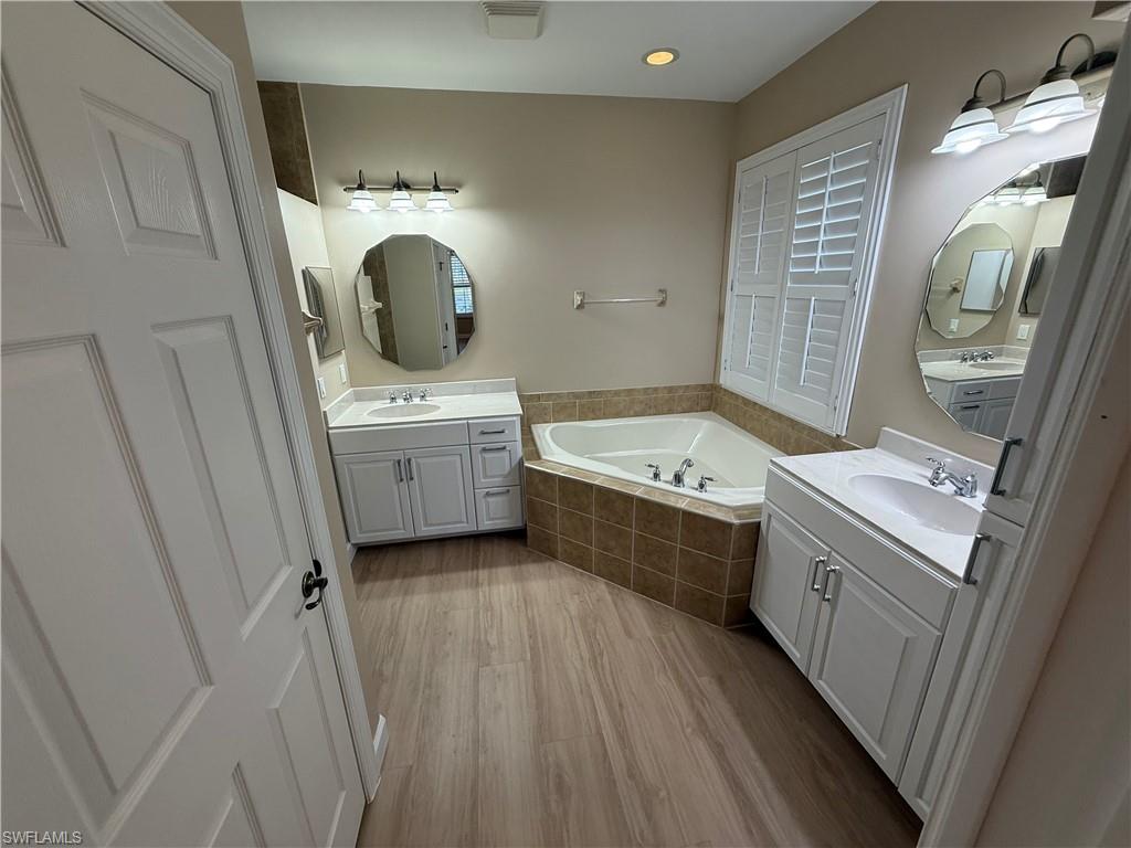 10228 Cobble Hill Road Bonita Springs, FL 34135 - Photo 15 of 31 Full bath featuring two vanities, a garden tub, and light wood-style floors