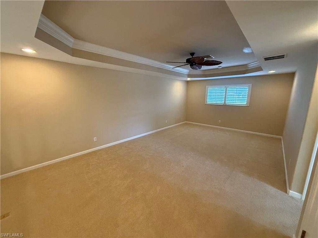 10228 Cobble Hill Road Bonita Springs, FL 34135 - Photo 17 of 31 Carpeted spare room featuring a tray ceiling, recessed lighting, crown molding, and ceiling fan