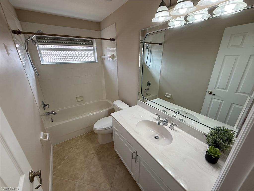 10228 Cobble Hill Road Bonita Springs, FL 34135 - Photo 19 of 31 Full bathroom with washtub / shower combination, vanity, and light tile patterned flooring