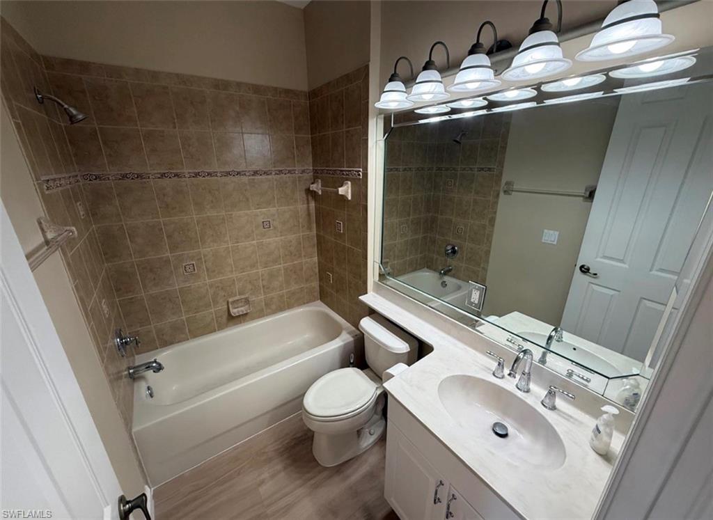 10228 Cobble Hill Road Bonita Springs, FL 34135 - Photo 28 of 31 Bathroom featuring washtub / shower combination, vanity, and wood finished floors