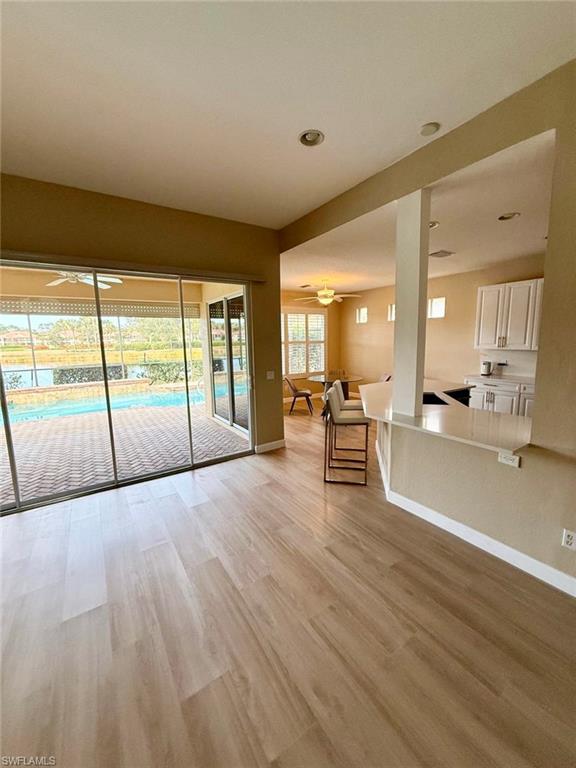 10228 Cobble Hill Road Bonita Springs, FL 34135 - Photo 4 of 31 Unfurnished living room featuring ceiling fan, light wood-style flooring, and recessed lighting