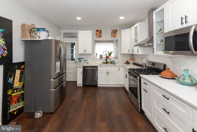 a kitchen with stainless steel appliances a stove a refrigerator a sink a stove and cabinets