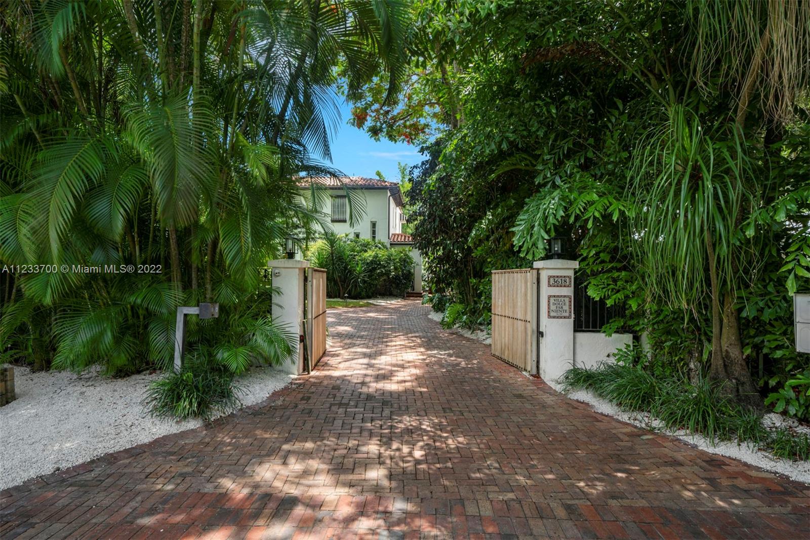 3618 St Gaudens Road Miami, FL 33133 - Photo 2 of 38 a view of a street with potted plants and large trees