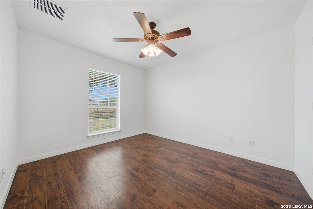 12897 La Vernia Road St. Hedwig, TX 78152 - Photo 25 of 34 an empty room with wooden floor a ceiling fan and wooden floor