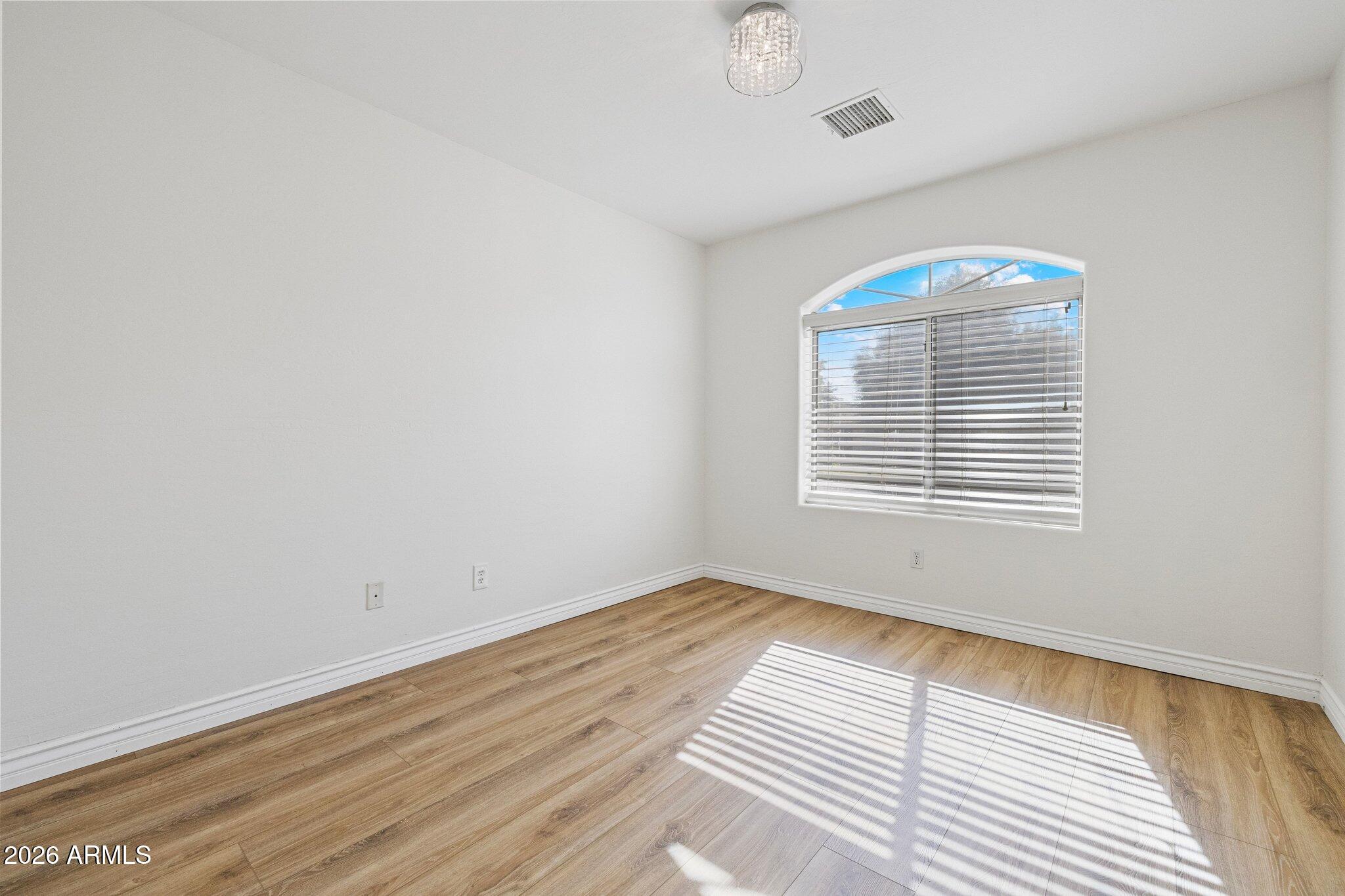 5233 North 15th Street Phoenix, AZ 85014 - Photo 15 of 26 a view of an empty room with wooden floor and a window